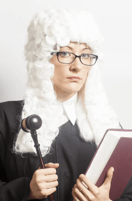 A judge in a full-bottomed wig holding a gavel and a red book.